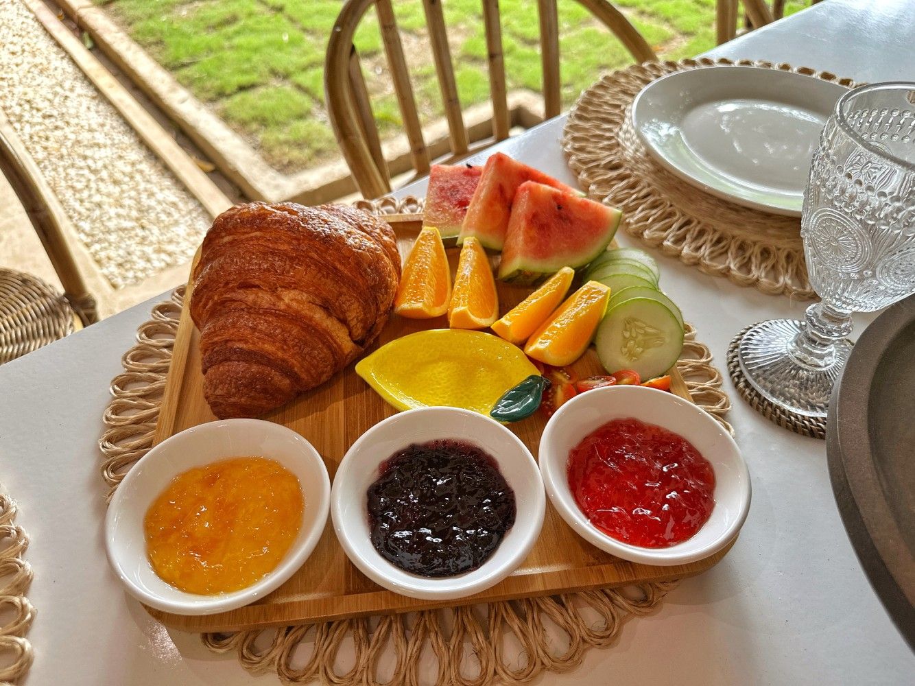 Breakfast platter with a croissant, fruit and three jams