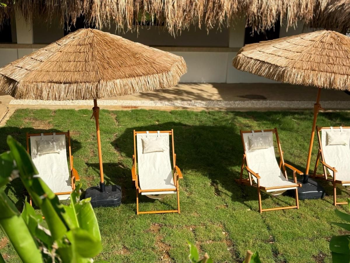 Sun loungers under thatched umbrellas on the lawn