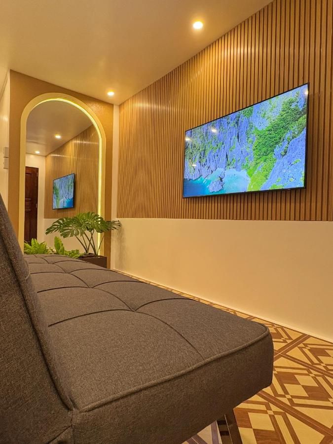 Lobby with an arched doorway, a timber-slat wall and a wall-mounted TV