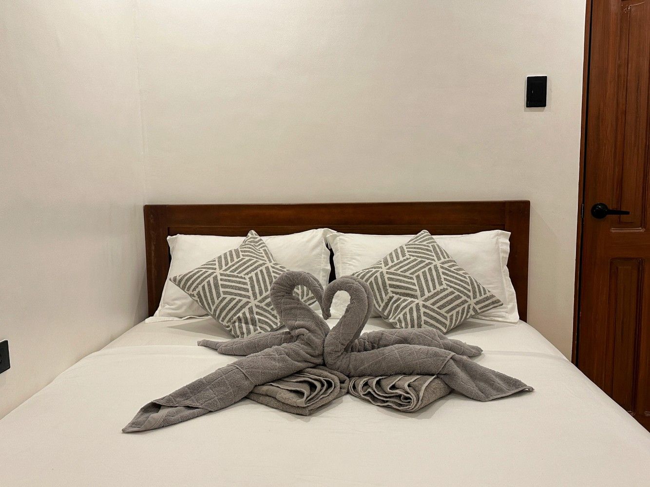 Double bed with towel swans in a La Luna Inn room