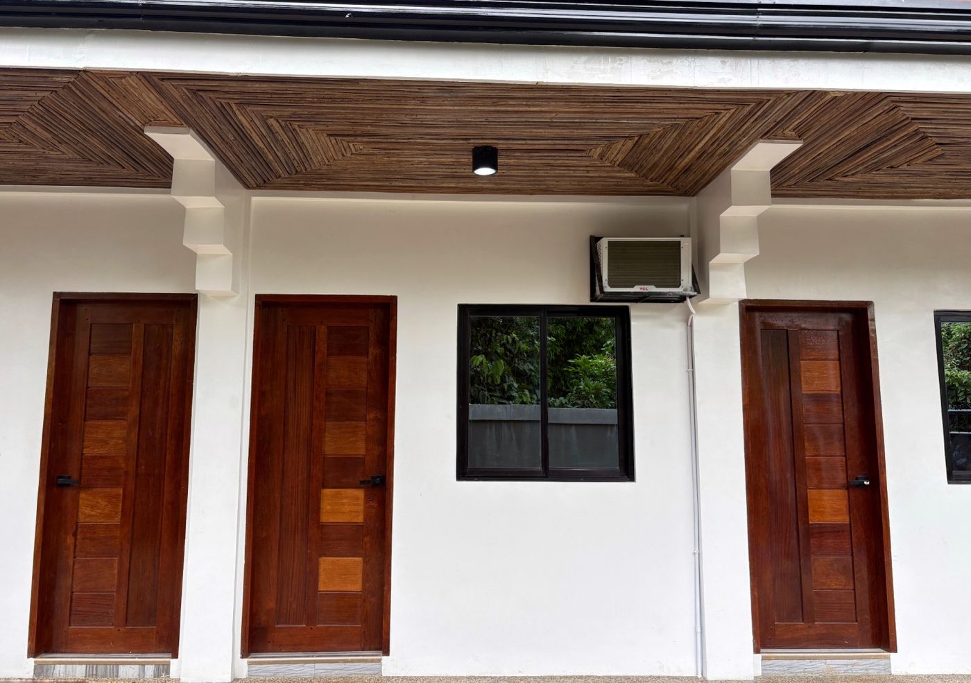 White facade with three hardwood doors
